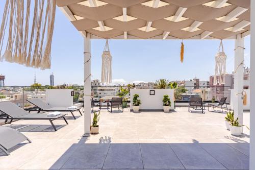 a patio with chairs and tables on a roof at Yamas Urban Living Platinum Key in Limassol