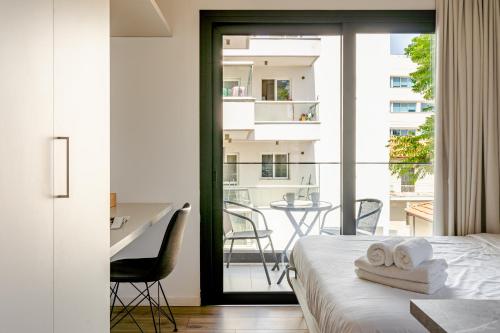 a bedroom with a bed and a balcony with a table at Yamas Urban Living Platinum Key in Limassol