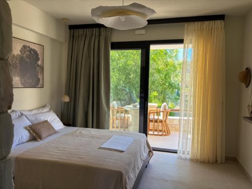 a bedroom with a bed and a sliding glass door at Noima Kalamitsi Boutique Studios in Kalamitsi
