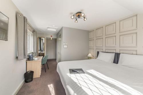 a bedroom with a large white bed and a desk at The Throckmorton in Alcester