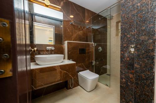 a bathroom with a sink and a toilet and a shower at Yellowstone Resort Arambol in Arambol