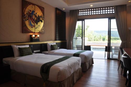 a hotel room with two beds and a balcony at Phurua Sanctuary Resort and Spa in Phu Rua
