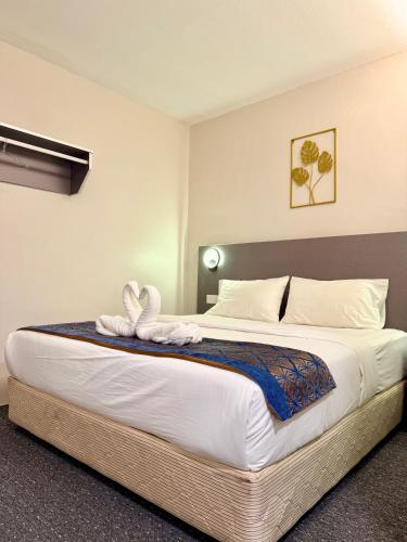 a bedroom with a large bed with white sheets at Hotel first garden in Kuantan