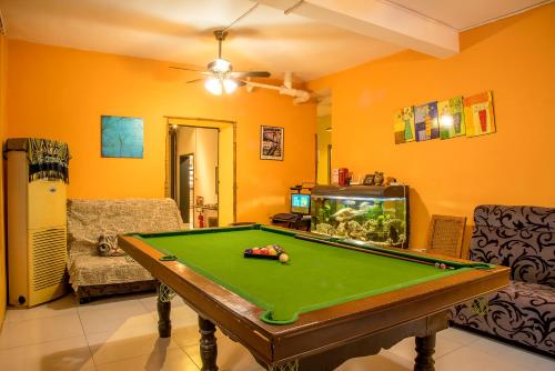 a living room with a pool table and a fish tank at Haikou Banana Hostel in Haikou