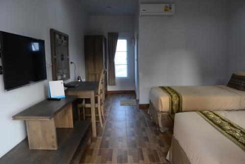 a hotel room with a desk and a television at Phurua Sanctuary Resort and Spa in Phu Rua