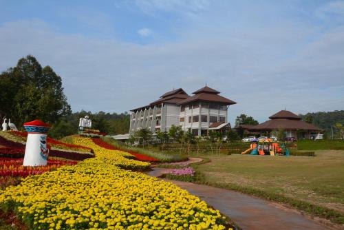 a garden of flowers in front of a building at Phurua Sanctuary Resort and Spa in Phu Rua