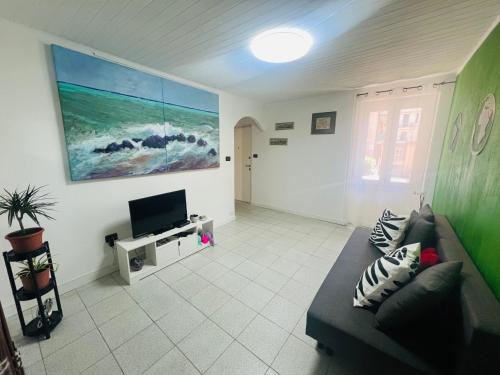 a living room with a couch and a flat screen tv at CASA BARBARA in Ventimiglia