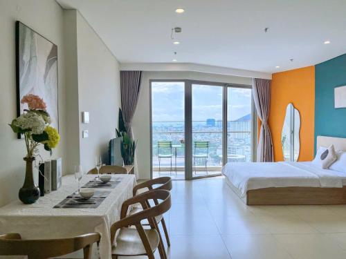 a bedroom with a bed and a table with chairs at CĂN HỘ NGHĨ DƯỠNG CAO CẤP THE SÓNG VŨNG TÀU-THE SONG APARTMENT LeeHuy in Vung Tau