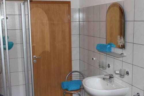 a bathroom with a sink and a wooden door at Ferienhof Leuner Sandro in Bad Schandau