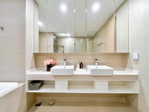 a bathroom with two sinks and a large mirror at CĂN HỘ NGHĨ DƯỠNG CAO CẤP THE SÓNG VŨNG TÀU-THE SONG APARTMENT LeeHuy in Vung Tau