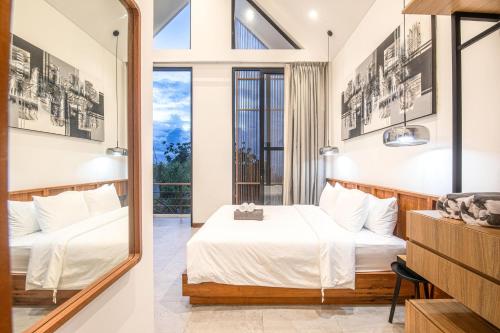 a hotel room with a bed and a mirror at Modern 2BR Villa Samudra Ocean View Nusa Dua in Ungasan