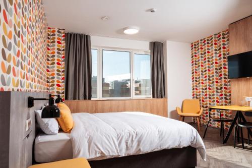 a bedroom with a bed and a table and chairs at Urban Ring Hotel in Ljubljana