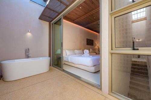 a bathroom with a tub and a bedroom with a bed at Peace House Koh Phi Phi in Phi Phi Islands