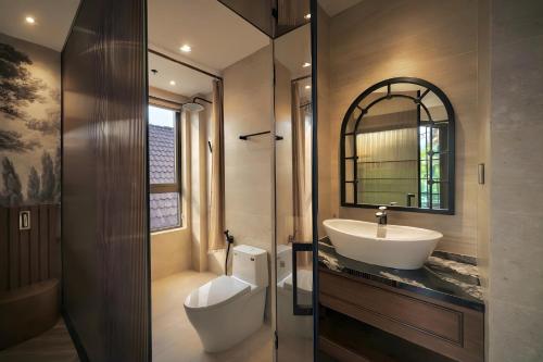 ein Badezimmer mit Waschbecken und Spiegel in der Unterkunft RIN Hotel Da Lat in Xuan An