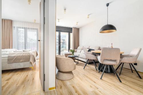 a living room and dining room with a table and chairs at Your Holidays Forest D141 in Międzyzdroje