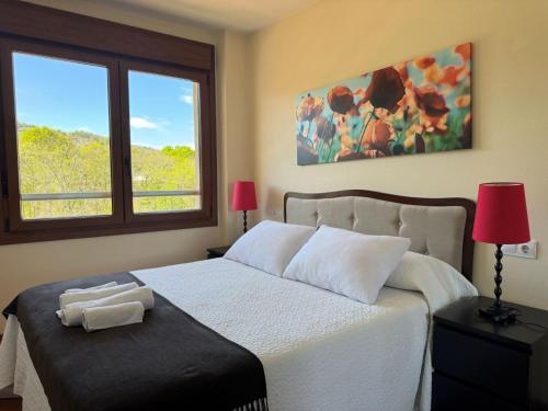 a bedroom with a white bed with a window at Apartamento El Abuelo en Cangas de Onís in Cangas de Onís
