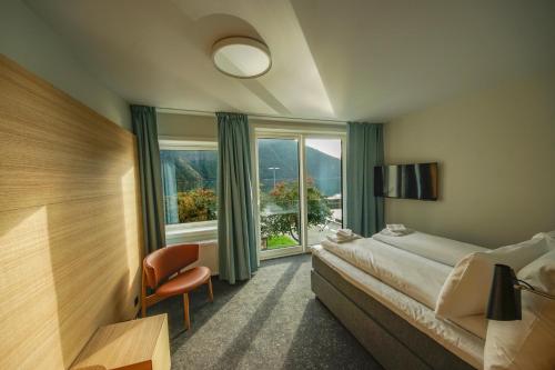 a hotel room with a bed and a window at Klingenberg Hotel - Årdal in Årdalstangen