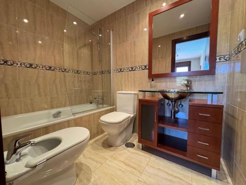 a bathroom with a sink toilet and a mirror at Apartamento El Abuelo en Cangas de Onís in Cangas de Onís
