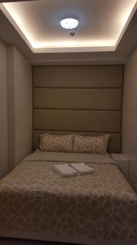 a bedroom with a bed with two towels on it at Suntrust Parkview Apartment in Manila