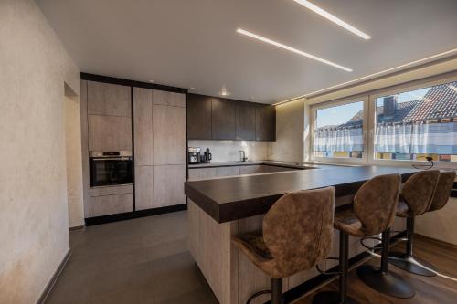 a kitchen with a counter and some chairs in it at Müller´s Talblick in Deggingen