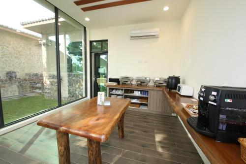a kitchen with a wooden table and a microwave at Kenting Four Season Villa in Hengchun