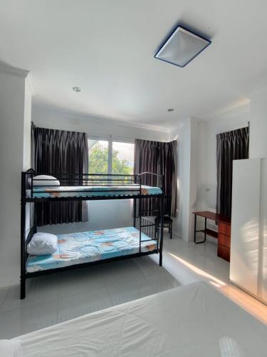 a bedroom with two bunk beds and a window at Home Valot Bed and Breakfast in Lan Saka