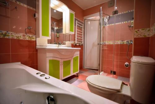 a bathroom with a tub and a toilet and a sink at Apartment Elegance in Stara Zagora