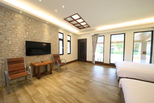 a bedroom with a bed and a tv on a brick wall at Kenting Four Season Villa in Hengchun