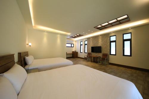 a hotel room with two beds and a television at Kenting Four Season Villa in Hengchun