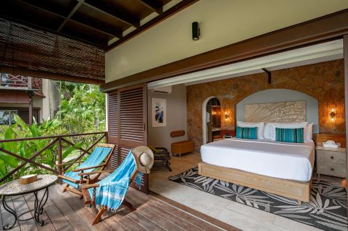 a bedroom with a bed and a balcony at Paradise Sun Hotel Seychelles in Baie Sainte Anne