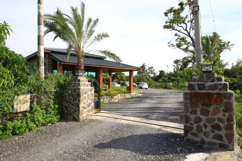 a road leading to a house with a palm tree at Kenting Four Season Villa in Hengchun