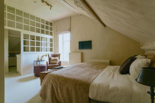 a bedroom with a large bed and a chair at Roomer in Landen