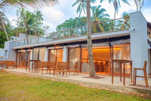 a resort with tables and chairs and palm trees at R Degrees Boutique Hotel & Spa in Ambalangoda