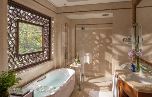 a bathroom with a tub and a sink and a window at Four Seasons Hotel Hangzhou at West Lake in Hangzhou