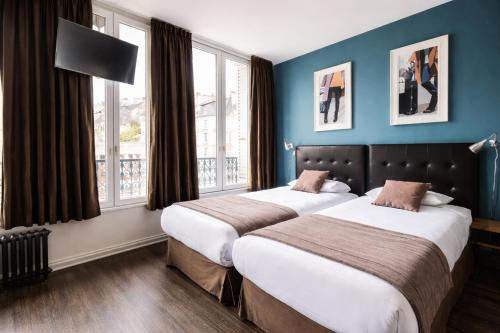 two beds in a hotel room with blue walls and windows at Urban Style Hôtel des Cèdres in Orléans
