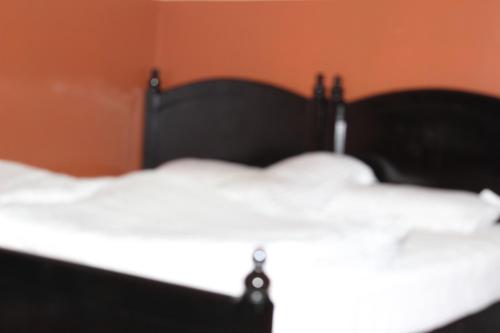 a close up of a bed with white sheets at Five Continents Hotel in Sur