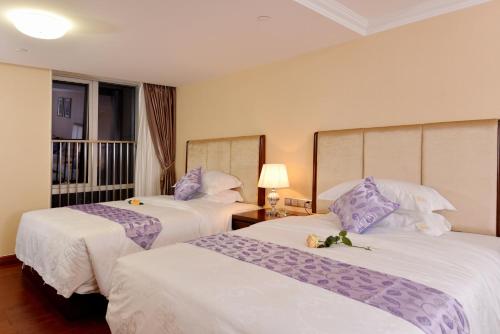 ein Hotelzimmer mit 2 Betten und einem Balkon in der Unterkunft Yo Le Le Apartment in Guangzhou