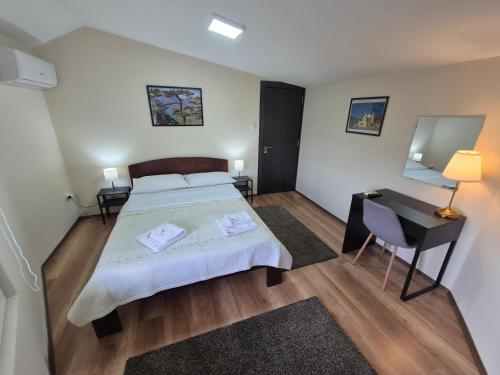 a bedroom with a bed and a desk and a mirror at Panorama Apartment in Belgrade