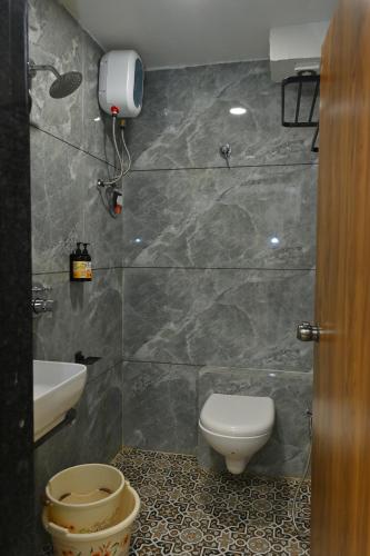 a bathroom with a toilet and a sink at Hotel Revanta Inn in Ahmedabad