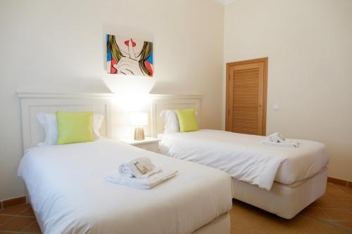 two beds with towels on them in a room at A Casa dos Príncipes in Amoreira