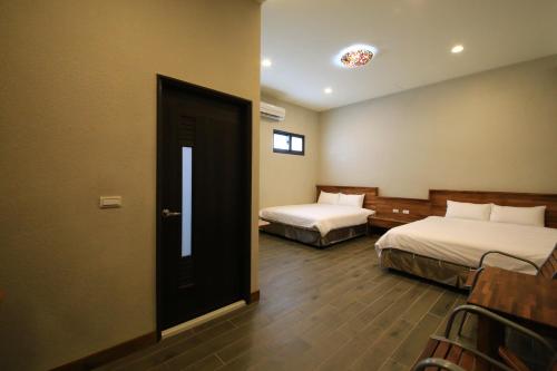 a hotel room with two beds and a door at Kenting Four Season Villa in Hengchun