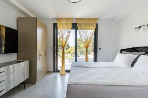 a bedroom with two beds and a large window at My Sea Lodge - Glaros Complex in Pefkochori