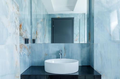 a bathroom with a white sink and a mirror at My Sea Lodge - Glaros Complex in Pefkochori