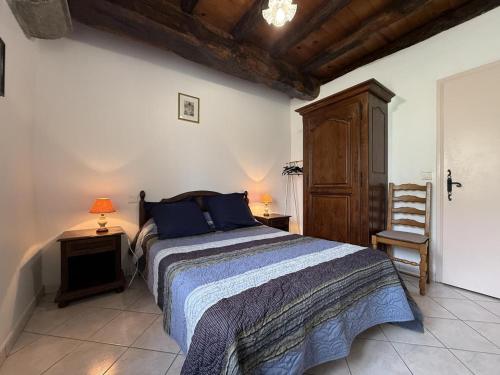 ein Schlafzimmer mit einem Bett, zwei Tischen und einem Stuhl in der Unterkunft Gorpulania in Arbonne
