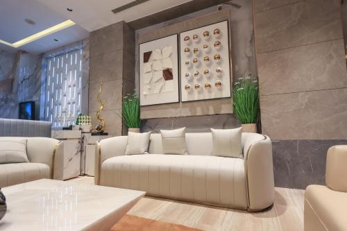 a living room with white couches and a wall at SKYLAR Tirupati in Tirupati