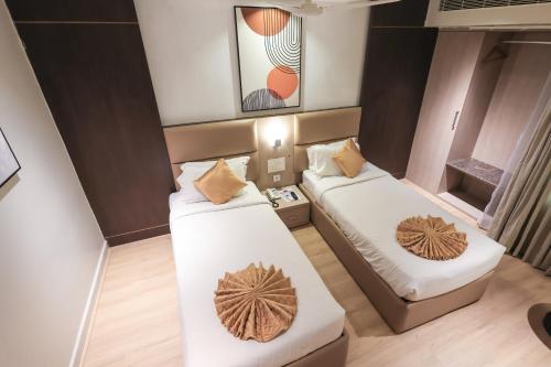 a small room with two beds in it at SKYLAR Tirupati in Tirupati