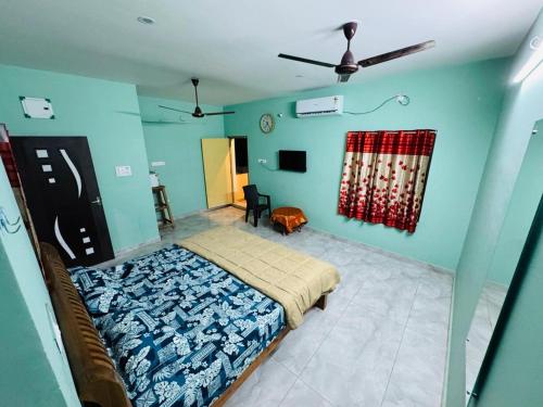 a bedroom with a bed and a blue wall at Gravity Groups SP homestay in Pondicherry