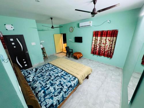 a bedroom with a bed in a room with blue walls at Gravity Groups SP homestay in Pondicherry
