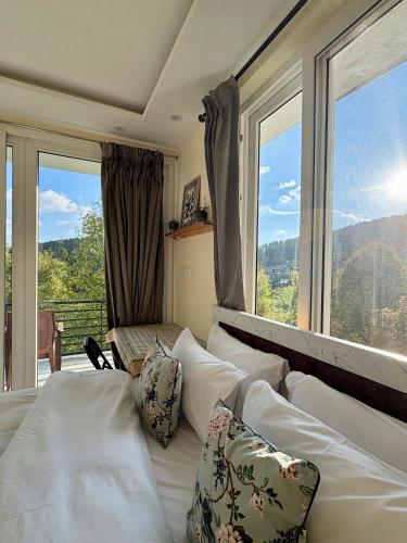 a bedroom with white beds and a large window at Soma House Dharamkot in McLeod Ganj