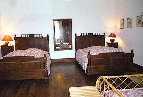 a bedroom with two beds and a mirror on the wall at Gîte robale in Romagne